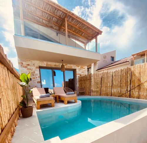 a villa with a swimming pool and a house at Amo Golden Suites in Chrysi Ammoudia