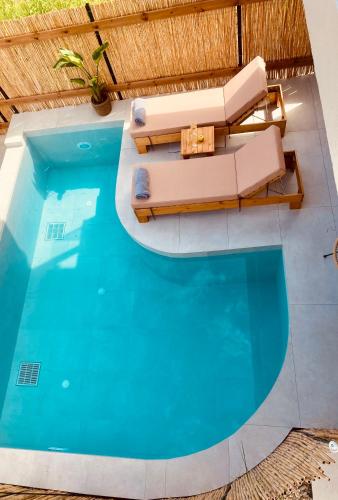 an overhead view of a swimming pool with a couch and a table at Amo Golden Suites in Chrysi Ammoudia