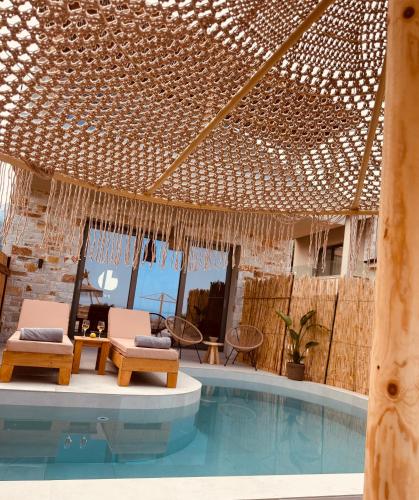 a resort with a swimming pool with two chairs at Amo Golden Suites in Chrysi Ammoudia