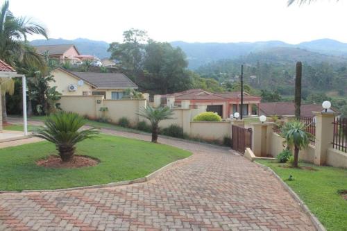 a house with a brick walkway in a yard at Ezulwini Zululami in Ezulwini