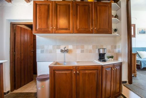 a kitchen with wooden cabinets and a sink at Black Sand in Moutsouna Naxos