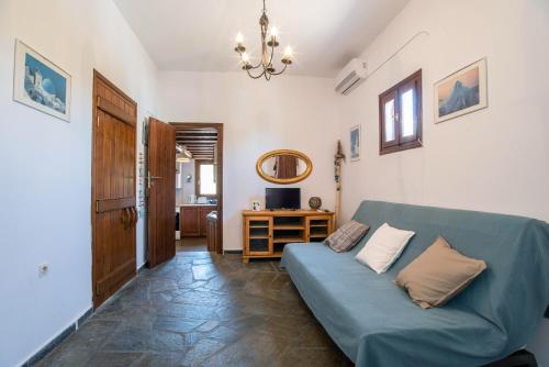 a living room with a blue couch and a table at Black Sand in Moutsouna Naxos