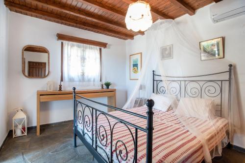 a bedroom with a bed and a staircase with a mirror at Black Sand in Moutsouna Naxos