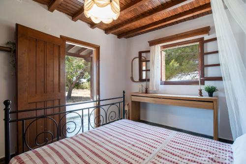a bedroom with a bed and a window at Black Sand in Moutsouna Naxos