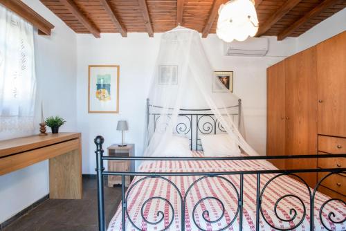 a bedroom with a bed with a canopy at Black Sand in Moutsouna Naxos