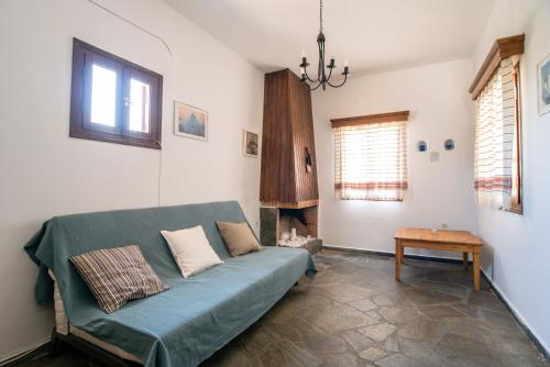 a living room with a blue couch and a fireplace at Black Sand in Moutsouna Naxos