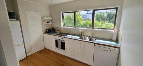 a small kitchen with a sink and a window at 2 Bedroom home, City and Sea Views in Auckland