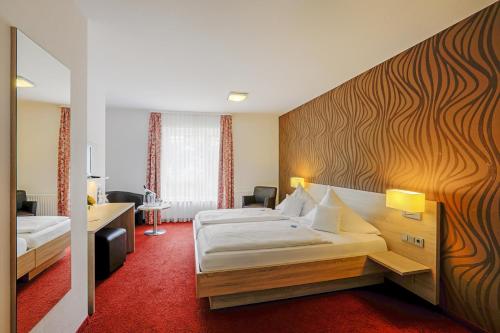 a hotel room with two beds and a red carpet at Lindenhof in Osterspai