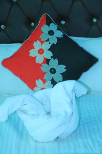a bed with a pillow with flowers on it at Hotel Diamond in Bharatpur