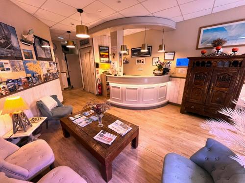 a living room with a table and chairs and a bar at Hotel des Abers in Saint Malo
