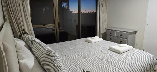 a bedroom with a bed with two towels on it at 2 Bedroom home, City and Sea Views in Auckland