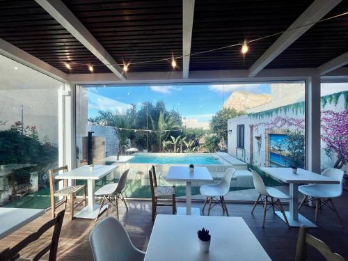 a restaurant with tables and chairs and a swimming pool at Ricordi Siciliani - Charme Rooms in San Vito lo Capo