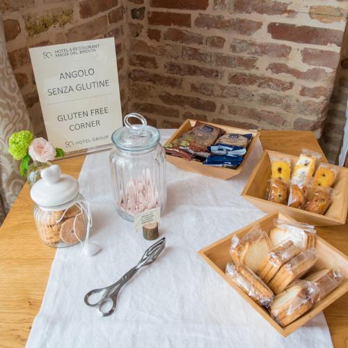 a table with two boxes of pastries and a jar of food at Hotel Ristorante Magia del Brenta in Fiesso dʼArtico