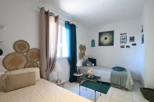 a bedroom with two twin beds and a window at Entre les Alpilles, la Mer, la Camargue, à huit kilomètres de ARLES ,Villa des jasmins ,piscine,3 chambres ,climatisation, wifi fibre in Raphèle