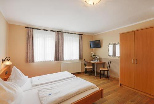 a bedroom with a bed and a table with a television at Lindenhof in Osterspai