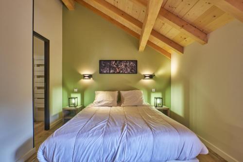 a bedroom with a bed in a room with wooden ceilings at La Grange in LʼHuez