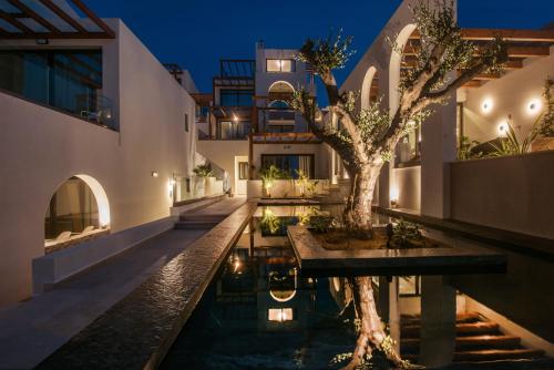 una casa con un árbol en medio de una piscina en Vaya Suites by Omilos Hotels, en Amoudara Herakliou