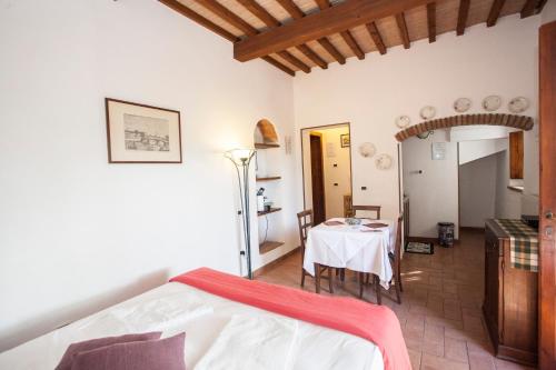 a bedroom with a bed and a table in a room at Garden Relais Le Fontanelle in Montescudaio