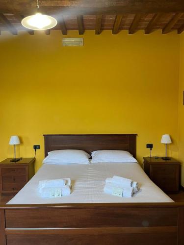 a bedroom with a large bed with a yellow wall at Sibolla Holidays in Altopascio