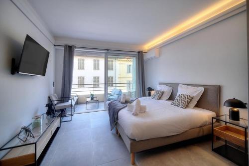 a bedroom with a large bed and a large window at Cannes Luxury Rental - Stunning apartment with terrace to rent Grand Hotel in Cannes