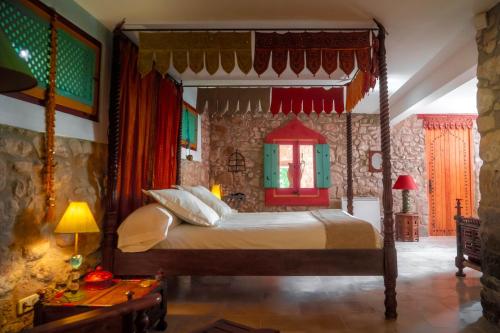 a bedroom with a canopy bed in a room at Can Serola in Sales del Llierca