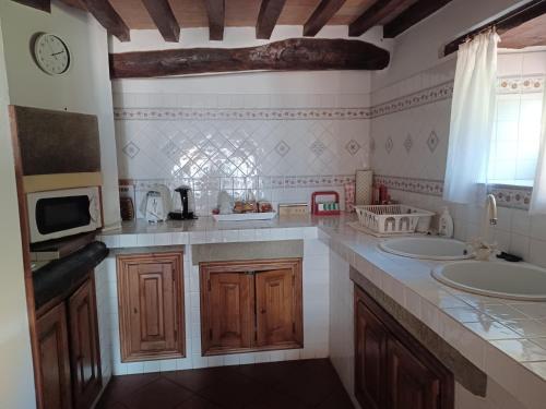 cocina con 2 lavabos y microondas en LE PIANACCE - Appartamento per vacanze, en Castiglione di Garfagnana