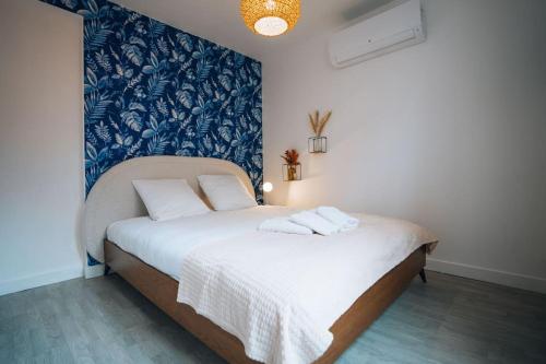 une chambre avec un lit avec un mur bleu et blanc dans l'établissement La Maison Bonheur - Parking Privé - Netflix - Fibre, à Châteauroux