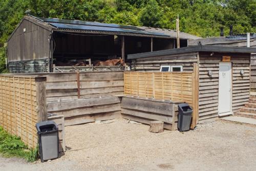 a wooden barn with a horse in the stable at Leto Shepherds Hut By Airpremier in Alfriston