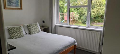 1 dormitorio pequeño con 1 cama y 2 ventanas en Riverfield Bed and Breakfast en Gorey