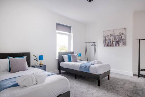 a bedroom with two beds and a painting on the wall at Recently renovated stylish home parking Pass the Keys in Bishop Auckland