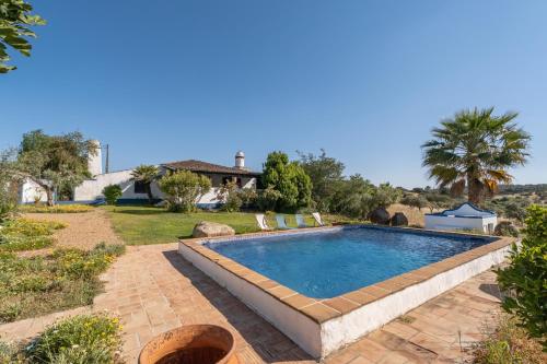 a swimming pool in a yard with a house at Monte das Acácias in Santo António do Baldio