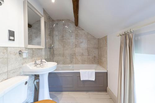 a bathroom with a sink and a bath tub at Charming Georgian Coach House in Hexham