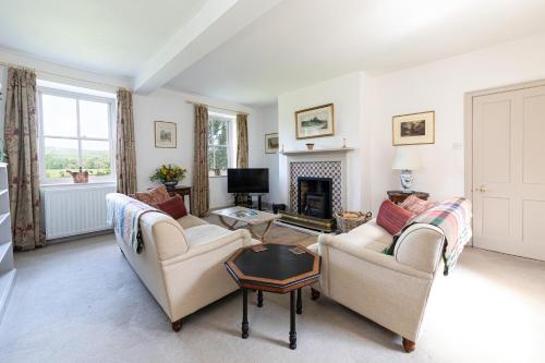 a living room with two couches and a fireplace at Charming Georgian Coach House in Hexham