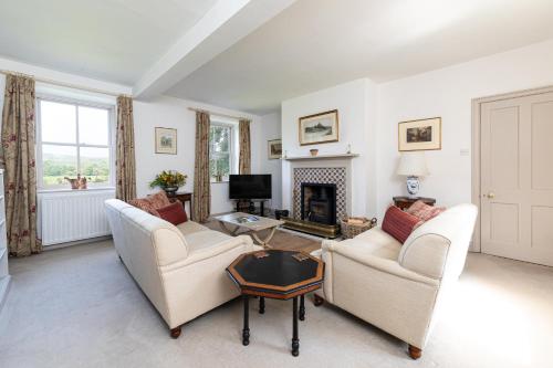 a living room with two couches and a fireplace at Charming Georgian Coach House in Hexham