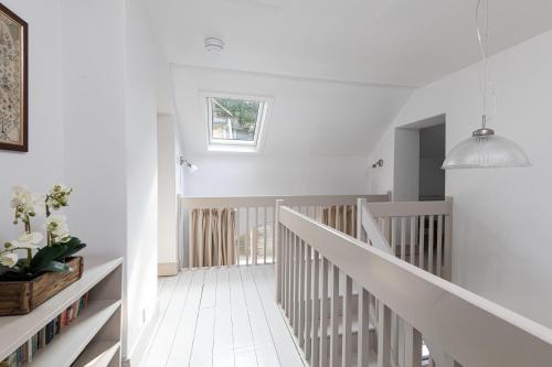 a white staircase in a home with a pendant light at Charming Georgian Coach House in Hexham