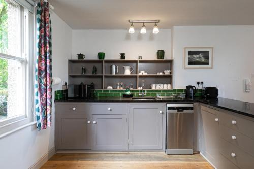 a kitchen with gray cabinets and a counter top at Charming Georgian Coach House in Hexham