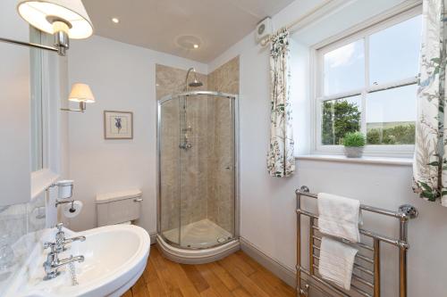 a bathroom with a shower and a sink at Charming Georgian Coach House in Hexham