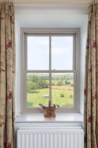 a window with a pot on a radiator in a room at Charming Georgian Coach House in Hexham
