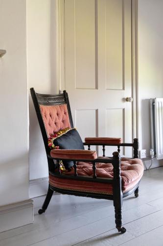 a chair with a pillow on it in a room at Charming Georgian Coach House in Hexham