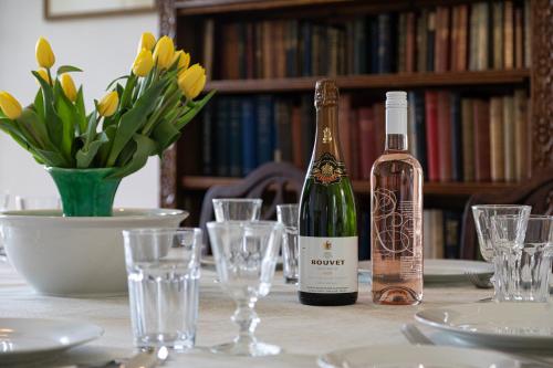 a bottle of wine sitting on a table with glasses at Charming Georgian Coach House in Hexham
