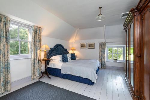 a bedroom with a bed and two windows at Charming Georgian Coach House in Hexham