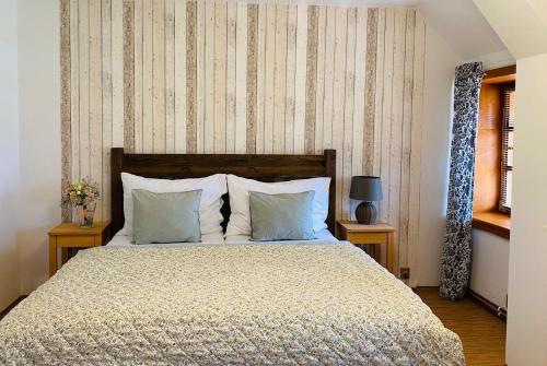 a bedroom with a large bed with two pillows at Penzion Jízdárna Hejtmánkovice in Broumov