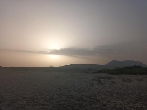 a sunset in the desert with the sun in the sky at Seaview studio in Neapolis