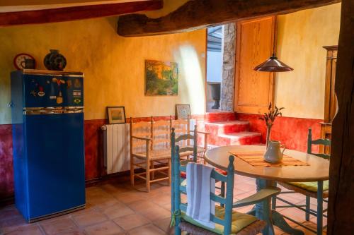 a kitchen with a table and a refrigerator in a room at Can Serola in Sales del Llierca
