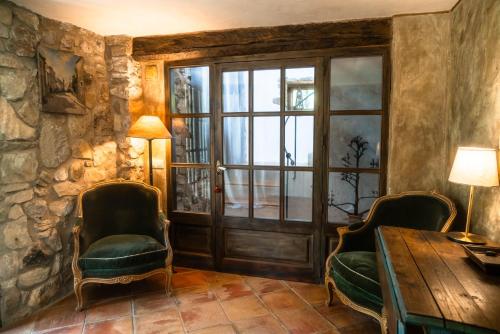 a room with a wooden table and chairs and a door at Can Serola in Sales del Llierca