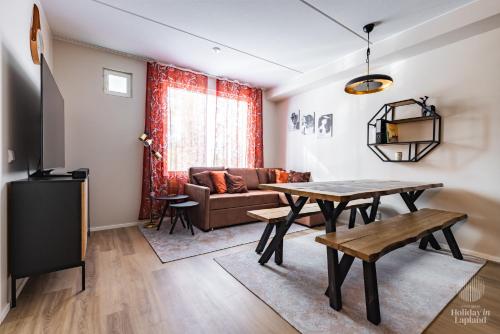 una sala de estar con una mesa y un sofá en Holiday in Lapland - LeviLeijona, en Levi