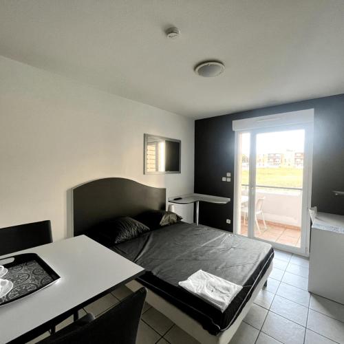 une chambre avec un lit, une table et une fenêtre dans l'établissement Casa du sud, à Béziers