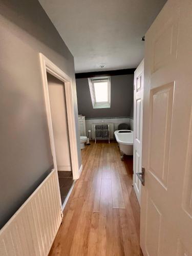 a bathroom with a toilet and a tub and a window at The Loft @ Brighouse in Brighouse