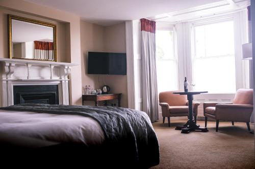 a hotel room with a bed and a chair and a fireplace at Castle Dargan Hotel in Sligo