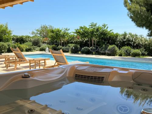 Una vista de una piscina con dos sillas al lado de una piscina. en White Pearl Villa Naxos with Private Swimming Pool, en Naxos Chora